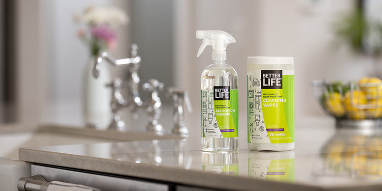 Two bottles of Better Life cleaners sit on a counter in a kitchen.