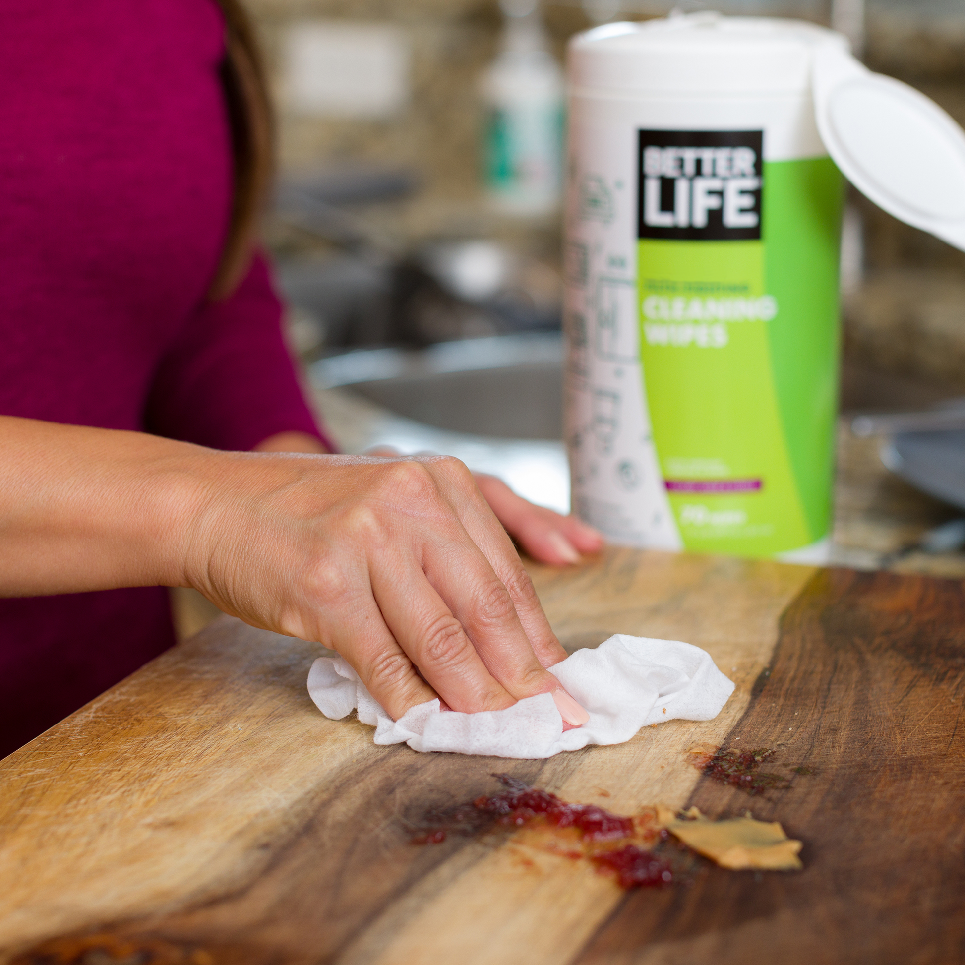 A lady cleaning surface with Better Life cleaning wipes