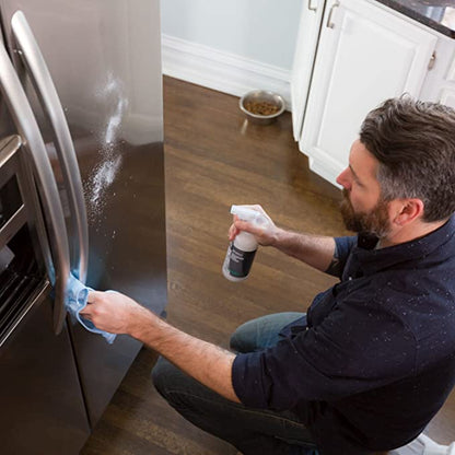 Man cleaning refrigerator with Clean Happens Stainless Steel Polish and a cloth.